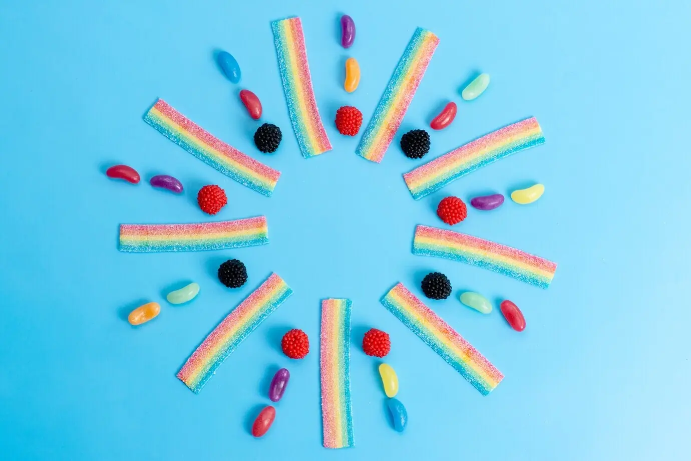 A top-down view of colorful marmalades and candies on blue, sweet sugary candy.